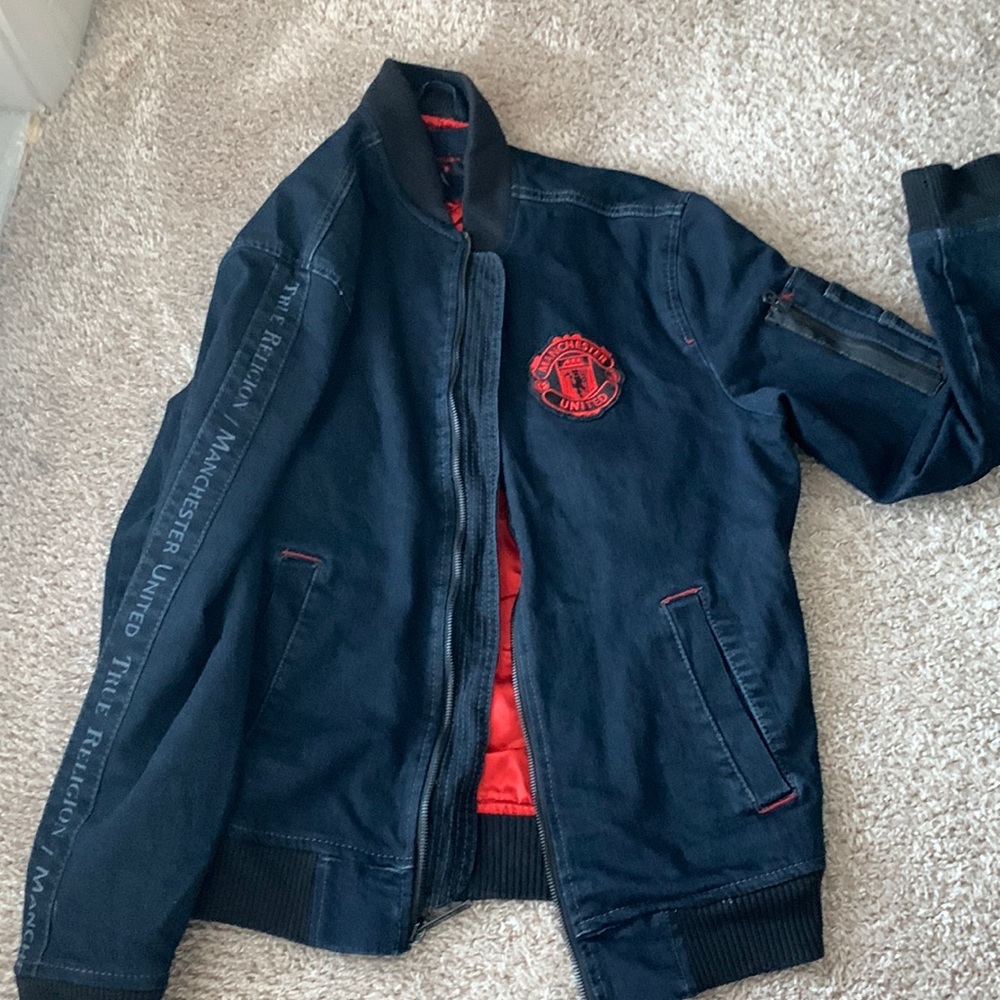 A large dark Jean jacket with red interior